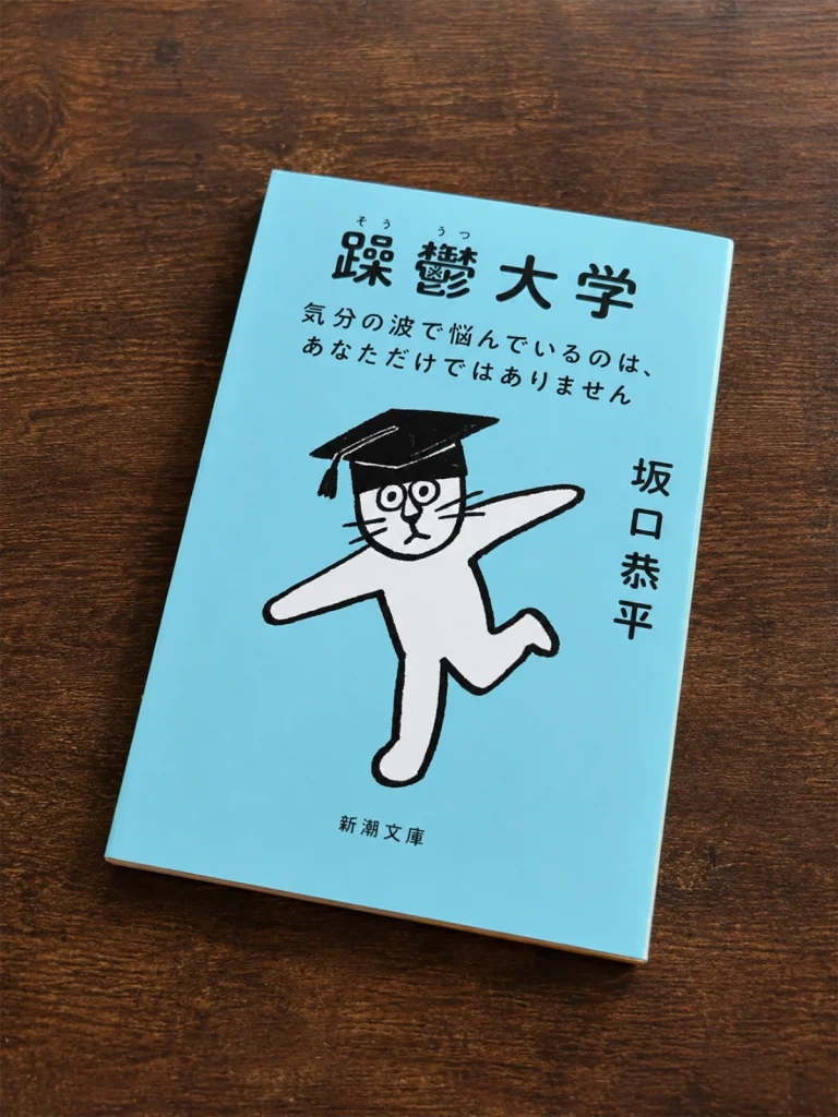 坂口恭平著『躁鬱大学』の本を木目の上に置いて撮影した写真
