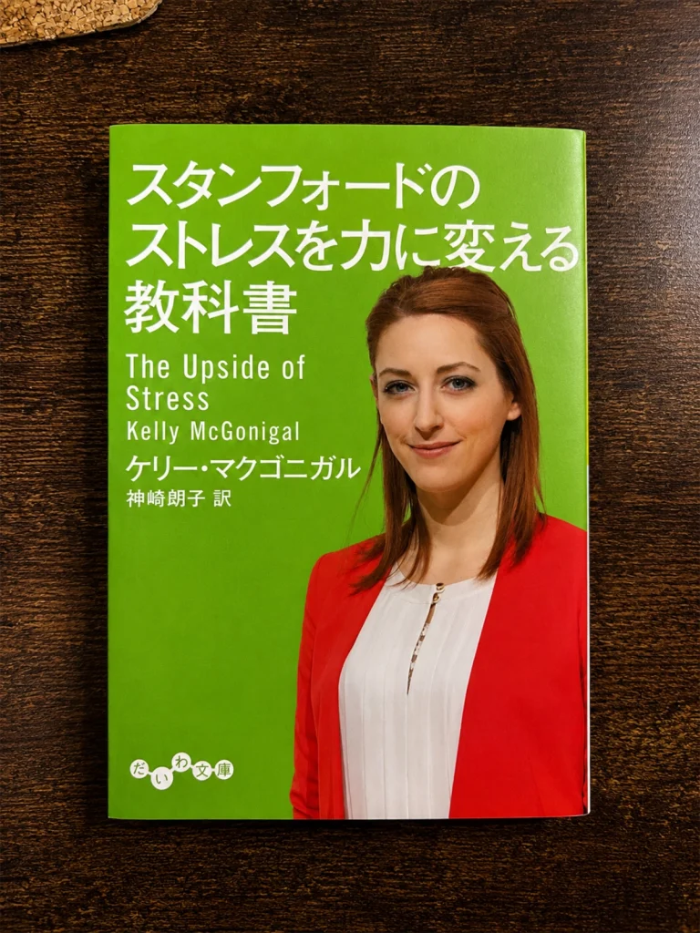 ケリー・マクゴニガル著『スタンフォードのストレスを力に変える教科書』の本を木目の上に置いて撮影した写真